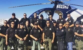 man-k9-police-squad-posing-for-photo-in-front-of-helicopter