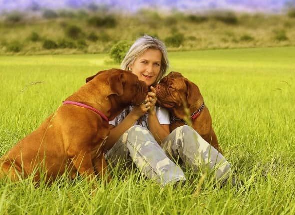 woman-receiving-kisses-from-two-dogs