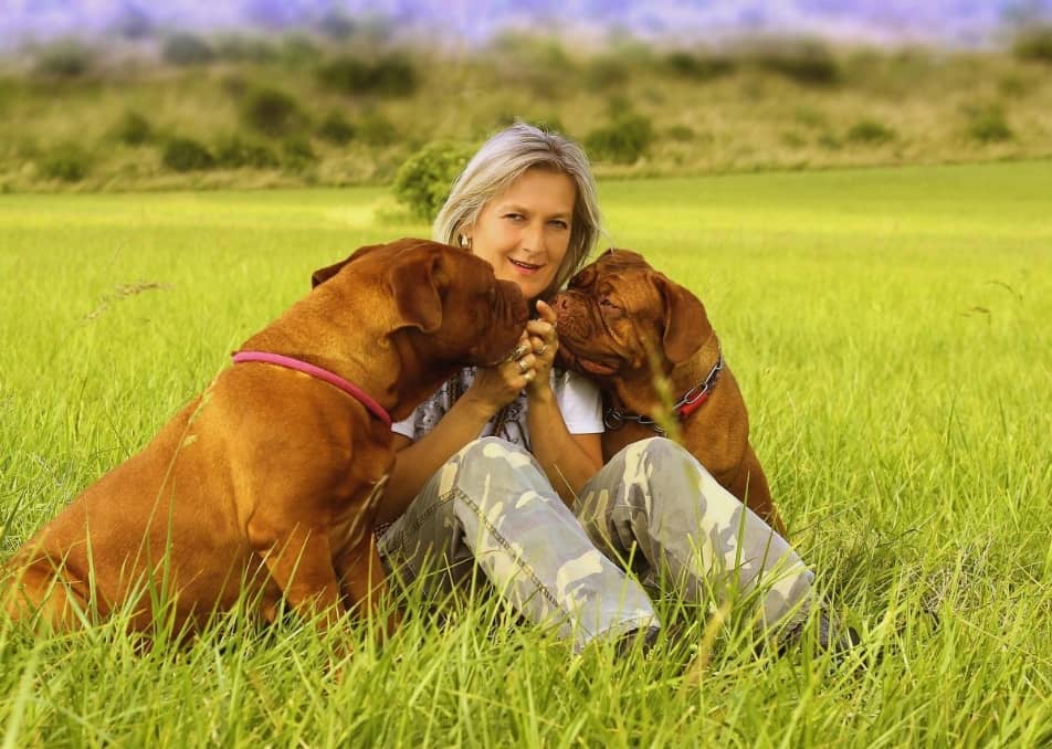 woman-receiving-kisses-from-two-dogs-1280x853